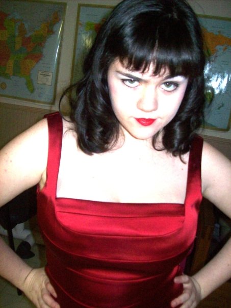 I look like this except no more bangs and I am probably 7 pounds heavier. Also I will probably leave my red dress at home and opt for an ensemble more appropriate for a 24-hour horrorthon.